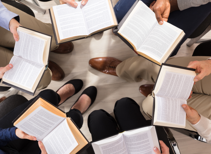 Foto referencial de personas leyendo un libro