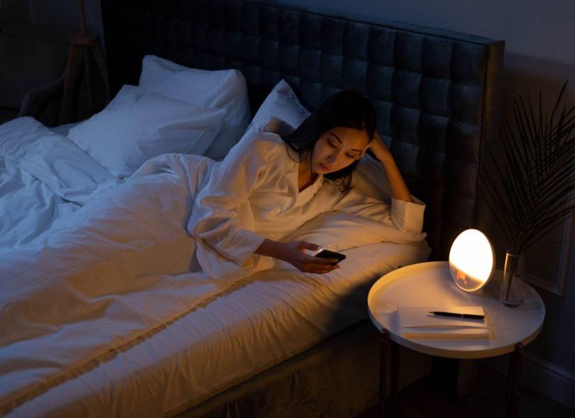 Imagen referencial: Mujer usando su celular durante despertar nocturno.