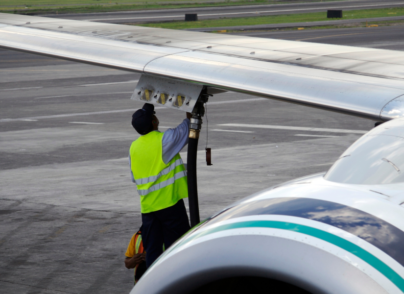 Foto referencial de una persona poniendo combustible a un avión