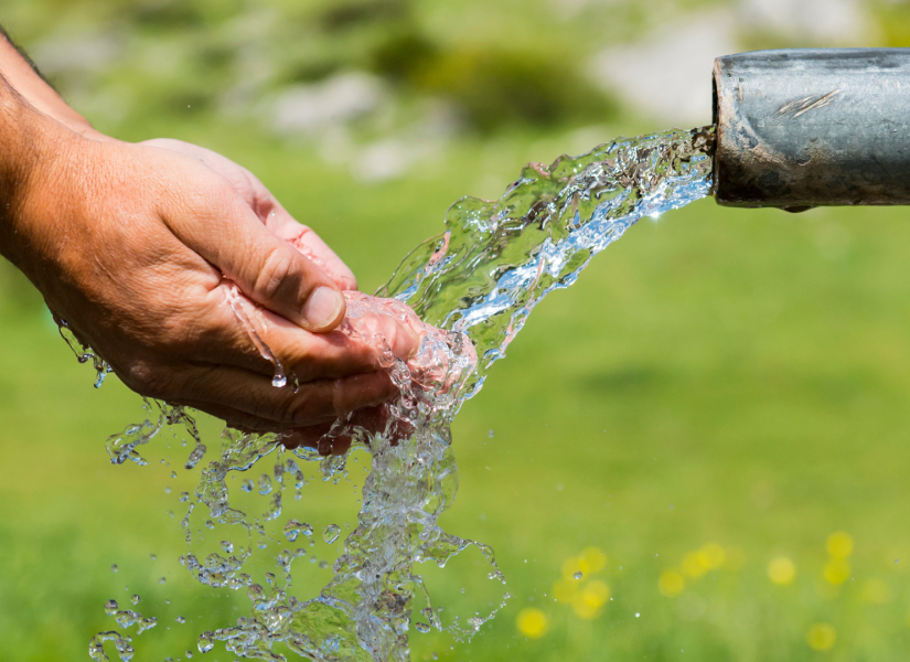 Foto referencial de una persona recogiendo agua d