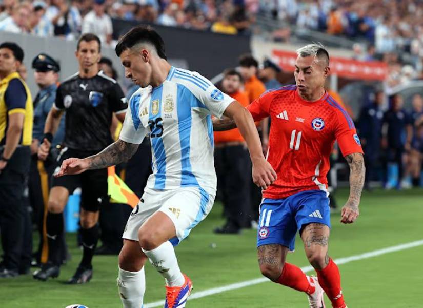 Lisandro Martínez y Eduardo Vargas disputando el balón.