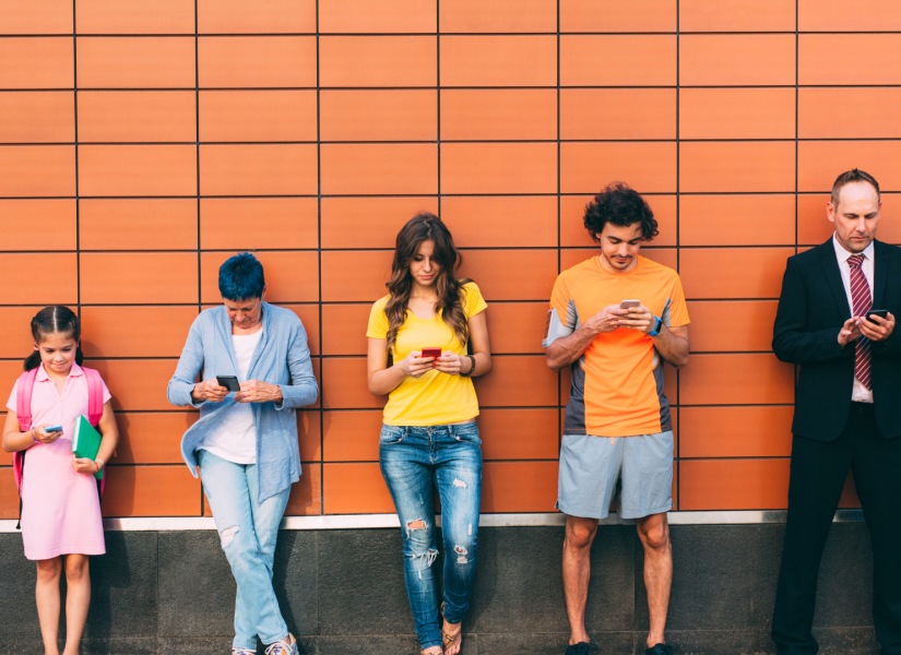 Foto referencial de distintas personas de diferentes edades en el celular