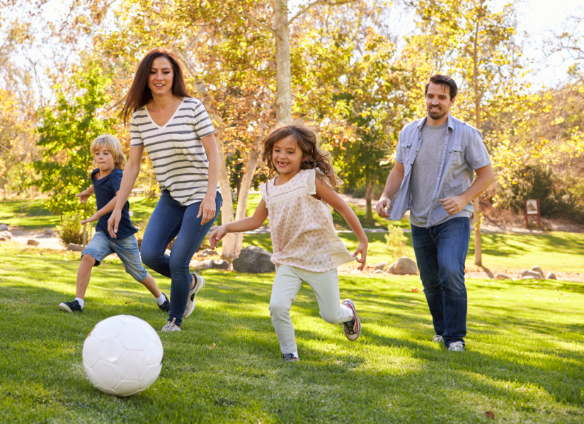 Imagen referencial de padres e hijos jugando fútbol.