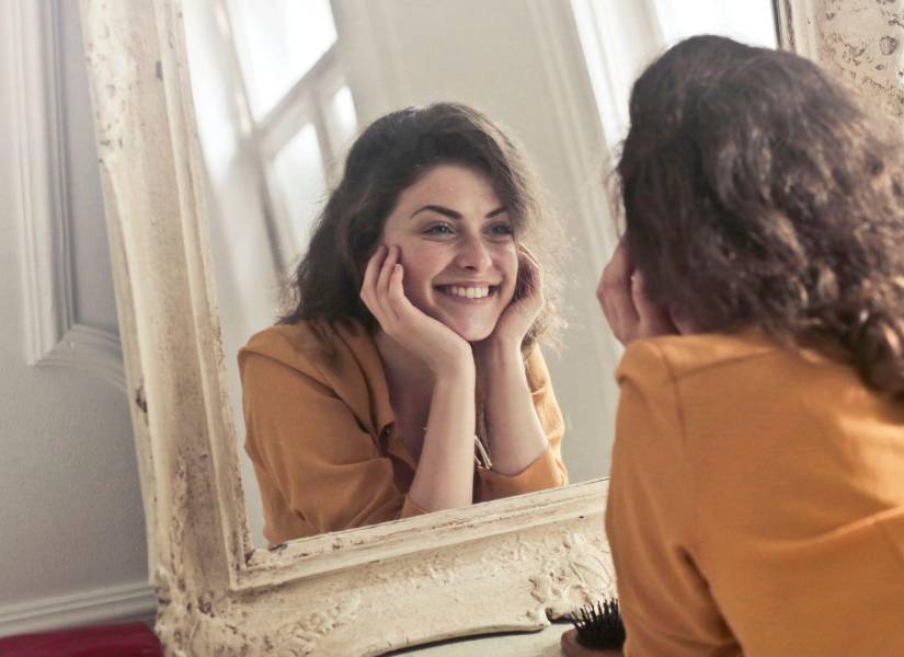 Imagen referencial de mujer conversando con ella misma frente al espejo.