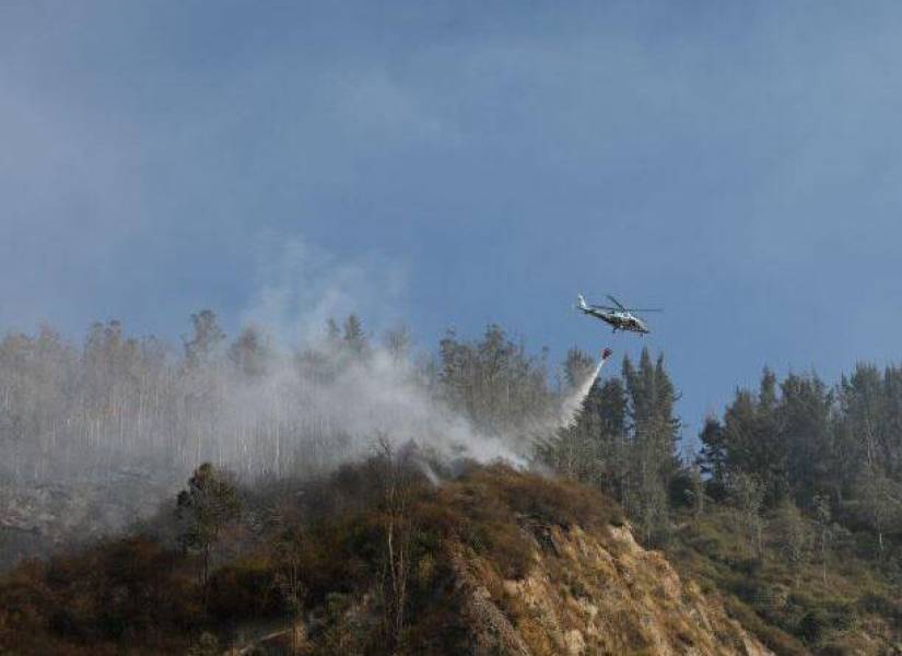 Uno de los helicópteros hace descargas de agua con el sistema Bambi Bucket.