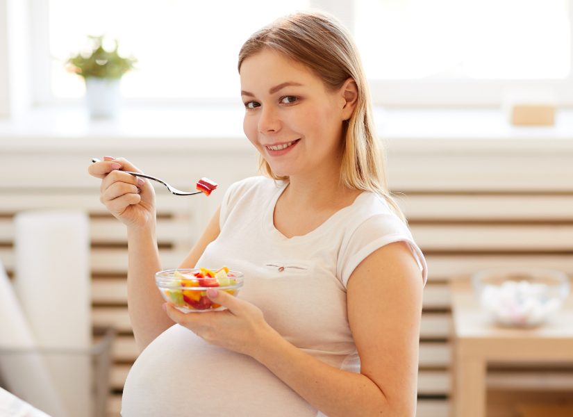 Mujer embarazada comiendo saludablemente.