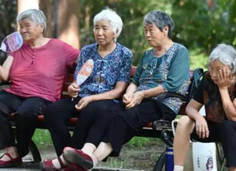 Imagen referencial de cinco ancianos de China sentados en una banca.