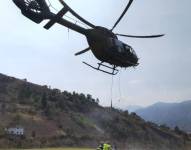 Un helicóptero carga agua para combatir los incendios forestales