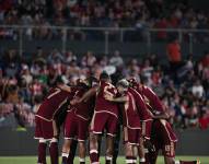 Jugadores de la selección de Venezuela reunidos en el centro del campo en un partido por las Eliminatorias