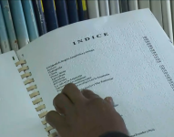 Imagen de una persona ciega leyendo un libro en braille.