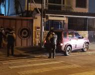 Imagen de un vehículo rodeado por policías, al comteres un asesinato.