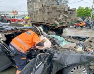 El impacto causó que parte de los bloques que transportaba el camión cayeran sobre el auto negro.