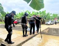 Imagen de agentes policiales recogiendo el cuerpo de un hombre armado con fusil en una bananera en Pasaje, El Oro, el sábado 21 de diciembre.