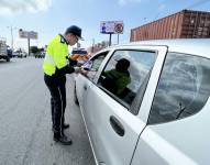 Imagen de un agente de tránsito de Durán conversando con un conductor.