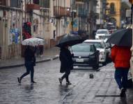 Personas cubriéndose con paraguas en Cuenca.