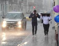 Lluvias en Cuenca, personas cubriéndose de las aguas.