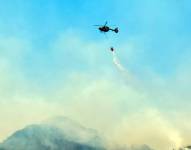 Helicópteros ayudan a sofocar el incendio forestal en el Parque Nacional Cajas.