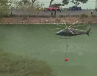 Imagen de un barquito alzando un gran balde con agua para apagar un incendio.