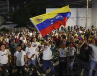 Un ciudadano venezolano ondea la bandera de Venezuela tras conocer los resultados electorales.