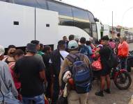 Migrantes hacen fila para abordar uno de los ocho autobuses del 'Corredor emergente de movilidad' en Tapachula (México).