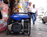 Un generador eléctrico conectado en una vereda, mientras da energía a un negocio.