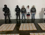 Imagen de un detenido junto a paquetes de droga.