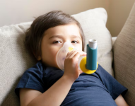 Niño haciendo uso de un inhalador