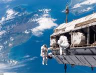 Los astronautas Robert L. Curbeam Jr. y Christer Fuglesang en la Estación Espacial Internacional, con Nueva Zelanda al fondo.