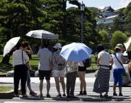 Varias personas se protegen del sol mientras pasean por los jardines del Palacio Imperial en Tokio, en una fotografía de archivo.