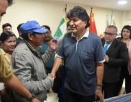 El expresidente Evo Morales saluda a un hombre en una rueda de prensa