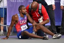 Noah Lyles recibiendo atención médica tras culminar la prueba de 200 metros planos.