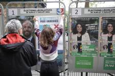Voluntarios colocan carteles de campaña durante la segunda vuelta de las elecciones parlamentarias francesas en París.