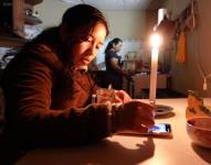 Dos personas realizando sus actividades sin luz.