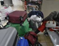 Imagen de una pasajera durmiendo en el aeropuerto de Quito con varias maletas, esperando por su vuelo.