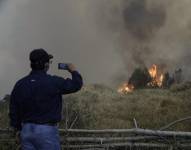 Un hombre graba con su celular un incendio forestal este martes, en Quito.