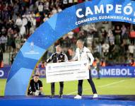 Isaac Álvarez y Esteban Paz reciben el premio económico por el título de Liga de Quito en la Copa Sudamericana, el 28 de octubre de 2023