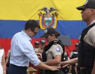 El presidente de la República, Daniel Noboa, coloca un chaleco a una policía.