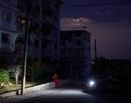 Un residente del barrio Naranjal Norte se sienta en la calle durante un corte de energía nocturno en la provincia de Matanzas, Cuba.