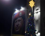 Fotografía de un cartel con la imagen del fallecido expresidente Hugo Chávez junto a un árbol de navidad, este lunes en Caracas (Venezuela).