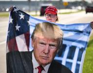 Una mujer sostiene un afiche de Trump en la ciudad de West Palm Beach, en Florida.