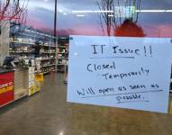 Una tienda muestra un cartel advirtiendo de problemas informáticos y que esta cerrado temporalmente
