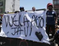 Integrantes de la barra Comandos Azules del equipo colombiano Millonarios alientan afuera del hospital San Ignacio para despedir a Javier Acosta este viernes, en Bogotá (Colombia).