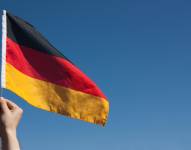 Imagen referencial: Mano sosteniendo una bandera alemana.