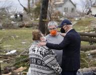 El presidente Joe Biden habla con unas personas mientras revisa los daños causados por unos tornados en Dawson Springs, Kentucky.