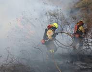 Dos bomberos apagando el fuego en Itulcachi.