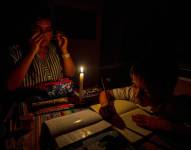 Una mujer y un niño, iluminados por una vela.