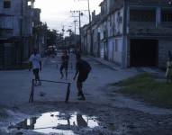 Varios jóvenes que juegan fútbol durante un apagón, en el municipio Cerro, en La Habana (Cuba).