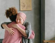 Imagen referencial de mujer con cáncer abrazando a su amiga.