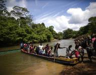 Fotografía de archivo de migrantes mientras descienden de una canoa antes de llegar a la Estación de Recepción Migratoria de Lajas Blancas luego de atravesar la selva del Darién.