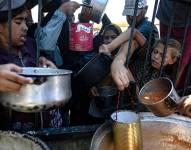 Palestinos desplazados intentan obtener alimentos donados por una organización benéfica, en el campamento de Khan Younis, en el sur de la Franja de Gaza, este martes.